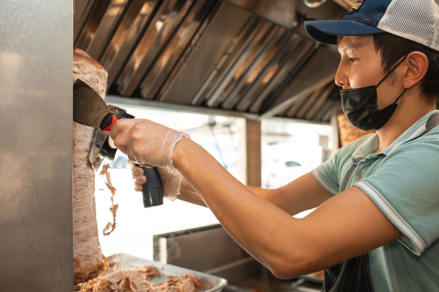 Vendor slicing shawarma inside the food truck