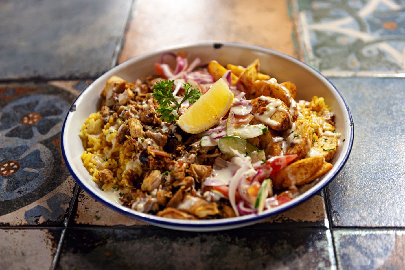 Chicken over rice with white sauce drizzle